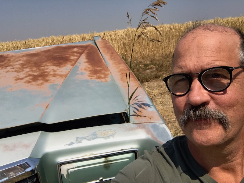 Krist with car and wheat field.